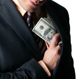 Close up of a business mans hand hiding money in his suit jacket pocket.